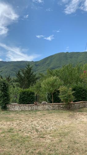 a stone wall in a field with mountains in the background at CASA VACANZE - LA CASINA DI LALLA - Greccio in Greccio