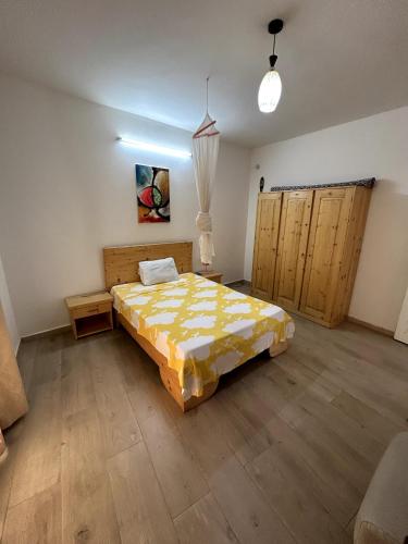 um quarto com uma cama num quarto com pisos em madeira em Chambre spacieuse avec balcon - salle de bain extérieure privée & breakfast em Saint-Louis