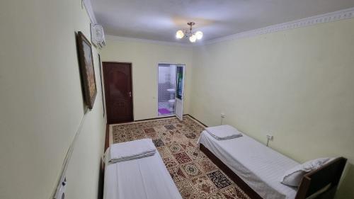 Habitación con 2 camas y ventana en Hotel Registon Zargaron, en Samarkand