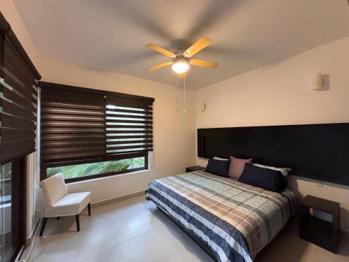 a bedroom with a bed and a ceiling fan at Golf & Beach Haven in Tulum