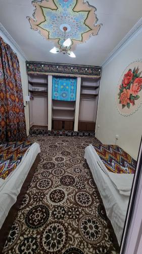 a room with two beds and a ceiling at Hotel Registon Zargaron in Samarkand