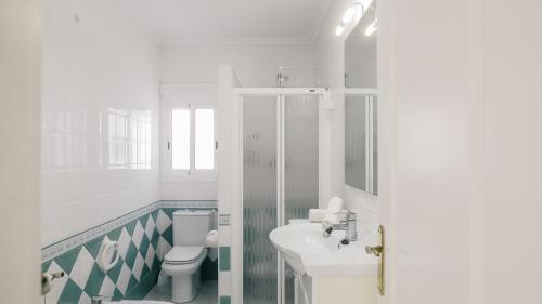 a white bathroom with a toilet and a sink at Casa Vesalia in Vinarós