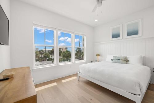 a white bedroom with a large bed and windows at Pearl House at The Gemma by Brightwild in Clearwater Beach