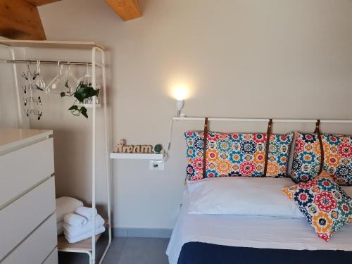 um quarto com uma cama com almofadas coloridas em CasAnna em Castellammare del Golfo