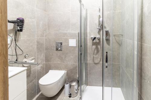 a bathroom with a toilet and a glass shower at Penzion Fiesta in Prostějov
