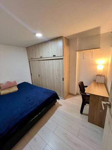 una camera con letto, scrivania e tavolo di Apartamento - Luz House a Bogotá
