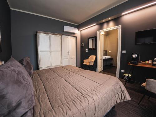 a bedroom with a bed and a table and a desk at Palazzo Gozzi Bed & Beauty in Parma
