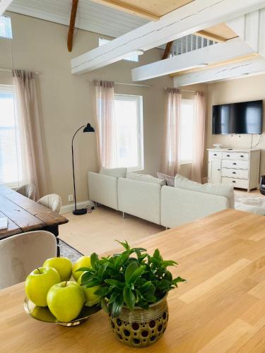 a living room with a table with a bowl of fruit at KokkolaDream - Historical Timber Home in Kokkola