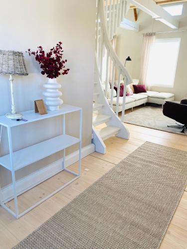 Una sala de estar con un estante azul con un jarrón de flores. en KokkolaDream - Historical Timber Home, en Kokkola