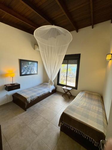 a bedroom with two beds and a window at Casa espectacular directo sobre el mar in Las Flores