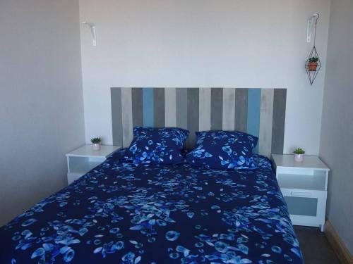 - une chambre avec un lit bleu et 2 oreillers dans l'établissement Appartement VUE MER avec balcon, WIFI et parking à Trégastel - FR-1-368-356, à Trégastel