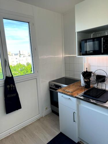 une cuisine avec un comptoir et une fenêtre dans l'établissement Chambre privée ds Appartement Design et Confort refait à neuf PROCHE de PARIS, la DEFENSE et VERSAILLES, à Rueil-Malmaison