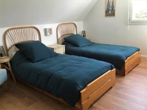- 2 lits avec des draps bleus dans une chambre dans l'établissement Maison de charme avec jardin, terrasse et WIFI à 600m de la mer - Trégastel - FR-1-368-360, à Trégastel