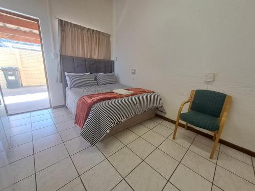 1 dormitorio con 1 cama, 1 silla y 1 ventana en Excel North Accommodation, en Ciudad del Cabo