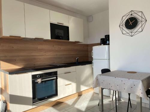 Il comprend une cuisine équipée d'une cuisinière, d'une table et d'un réfrigérateur. dans l'établissement T1 rénové avec balcon, clim, wifi, à Balaruc-les-Bains - FR-1-553-220, à Balaruc-les-Bains