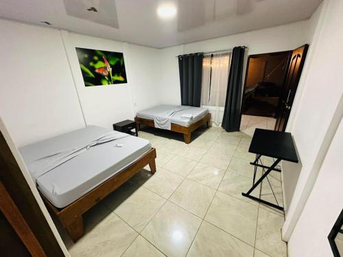 ein Schlafzimmer mit 2 Betten und einem Tisch darin in der Unterkunft TARPON LODGE PARISMINA in Jaloba