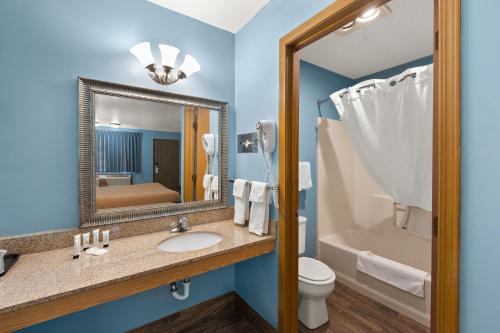 a bathroom with a sink and a toilet and a mirror at Americas Best Value Inn-Celina in Celina