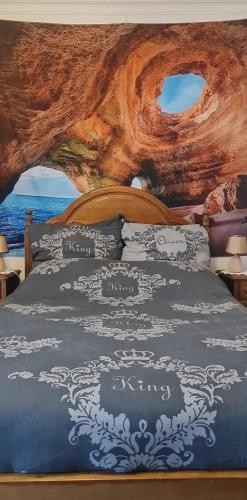 a bedroom with a bed with a painting on the wall at O Paraíso no Terraço in Foz do Arelho