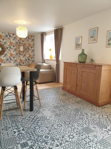 a living room with a table and a couch at Gîte proche de Sainte Mère Eglise in Montebourg