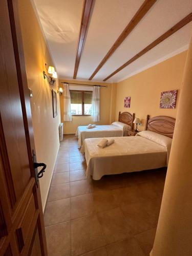 Cette chambre comprend 2 lits et une fenêtre. dans l'établissement Apartamentos Cuesta de la Cruz, à Caravaca de la Cruz