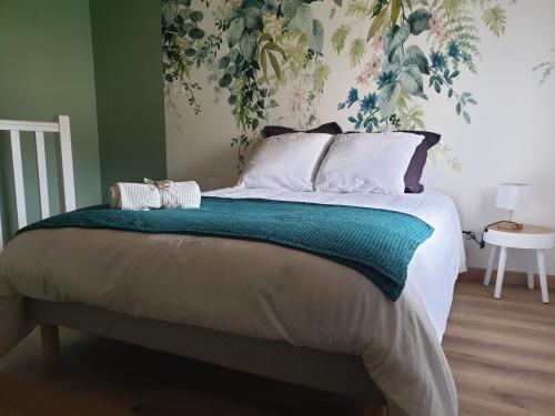 a bedroom with a large bed with a green wall at Gîte proche de Sainte Mère Eglise in Montebourg