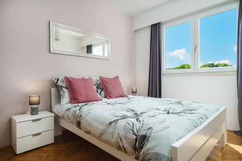 una camera bianca con letto con cuscini rossi e specchio di Apartment Remy a Vodice