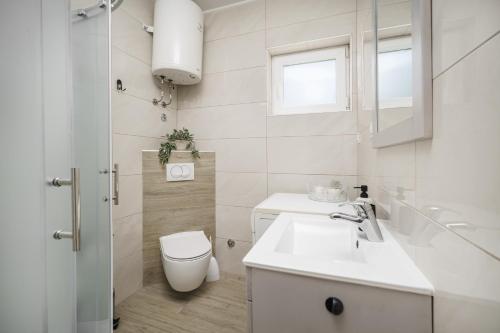 bagno bianco con servizi igienici e lavandino di Apartment Remy a Vodice