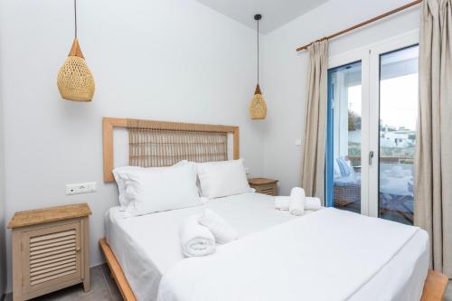 a bedroom with two beds and a balcony at Alsea Seafront Apartments in Agia Pelagia Kythera in Agia Pelagia