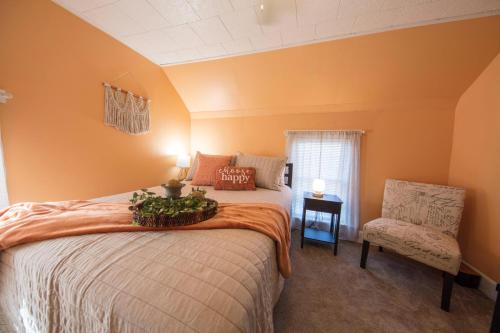 a bedroom with orange walls and a bed and a chair at Wayfarer Inn in Dalton