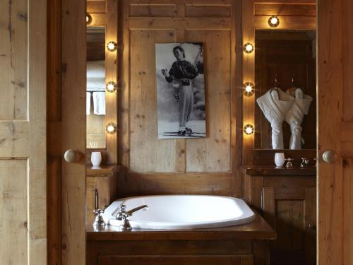 La salle de bains est pourvue d'une baignoire et d'une photo murale. dans l'établissement Hotel Mont Blanc Megève, à Megève