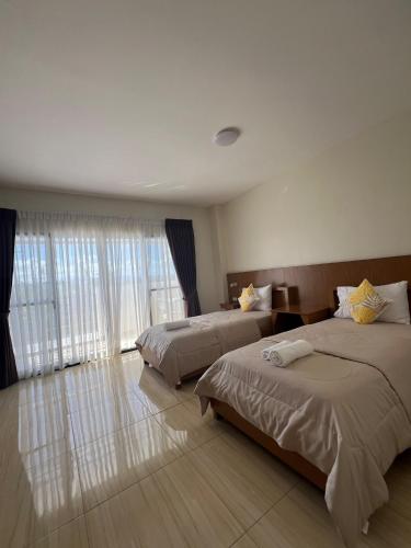 a hotel room with two beds and a window at LB Pietz Pension House in Cordova