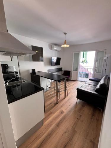 Il comprend une cuisine et un salon avec une table. dans l'établissement Appartement T2 Vieux Port d'Ajaccio, à Ajaccio