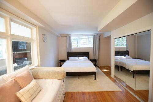 1 dormitorio con 2 camas y sofá en Private Garden-Level Suite, en West Vancouver