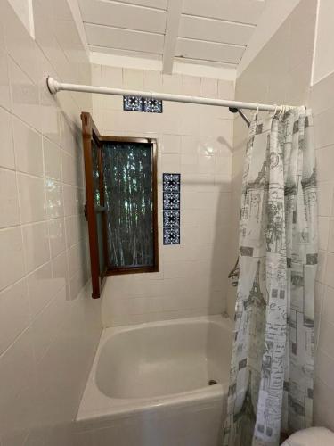 a bathroom with a tub and a shower curtain at SOBRE RIELES VAGON in San Lorenzo