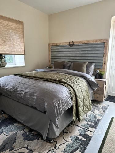 een slaapkamer met een groot bed met een houten hoofdeinde bij Green Pasture in Much Birch