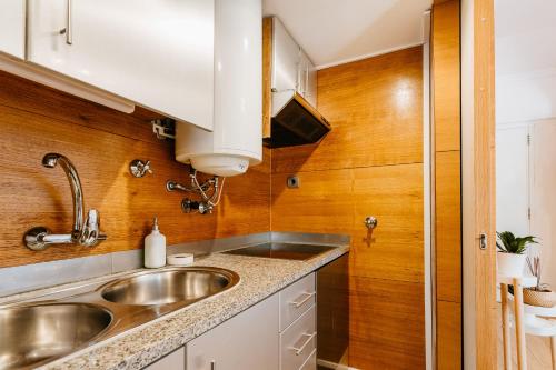 a kitchen with a sink and wooden walls at Nomad Dreams N1 in Cascais