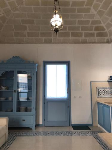 a living room with a blue door and a window at Blu Rooms Marettimo in Marettimo