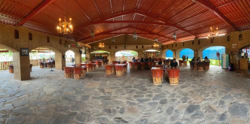 a lobby with tables and chairs in a building at Frutos Hotel in Ameca