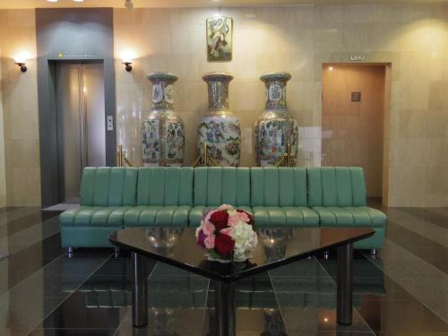 a green couch in a room with three vases at 南福岡グリーンホテル-Minami Fukuoka Green Hotel in Fukuoka