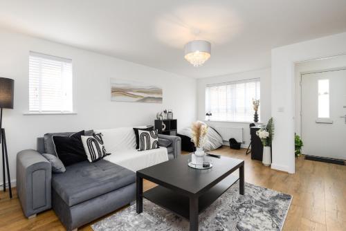 a living room with a couch and a table at Spacious 3 Bedroom House In Canterbury with Garden and Driveway - Sleeps 7 in Canterbury