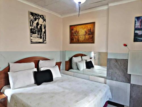 una camera con due letti e quadri alle pareti di Valleycenter guesthouse a Johannesburg