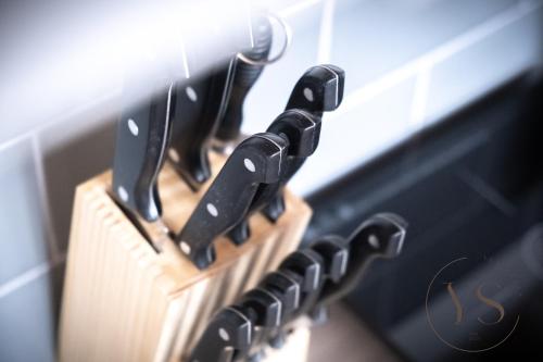 a wooden block of knives hanging on a wall at Bright Longton Studio B Near Alton Towers with Netflix and Free Wi-Fi in Stoke on Trent