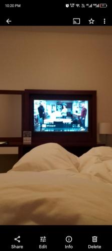 a bedroom with a bed with a tv on the wall at Dealer hotel in Al Jubayl