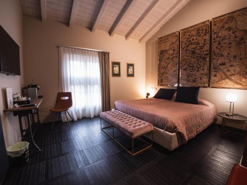 a bedroom with a bed and a desk and a window at Palazzo Gozzi Bed & Beauty in Parma