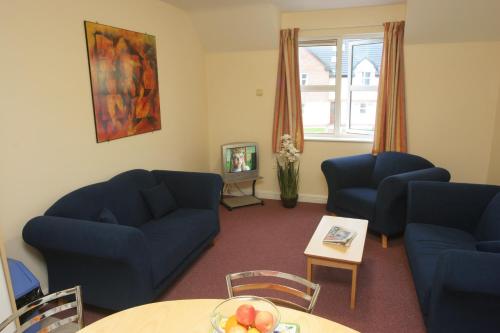 ein Wohnzimmer mit 2 blauen Sofas und einem Tisch in der Unterkunft 47 Yeats Village, Ballinode Sligo in Sligo