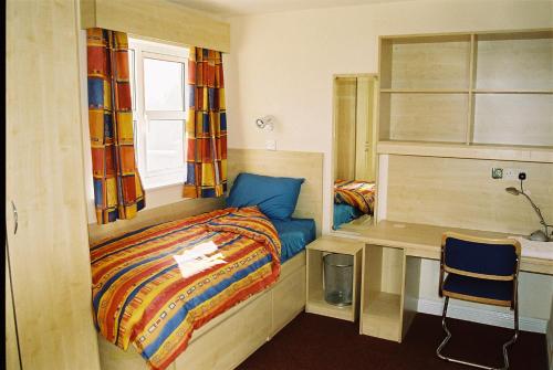 um pequeno quarto com uma cama e uma secretária em 47 Yeats Village, Ballinode Sligo em Sligo
