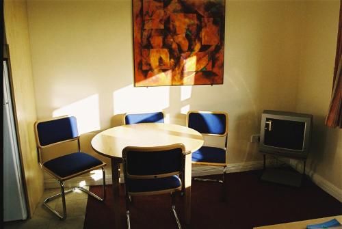 um quarto com uma mesa e cadeiras e uma televisão em 47 Yeats Village, Ballinode Sligo em Sligo