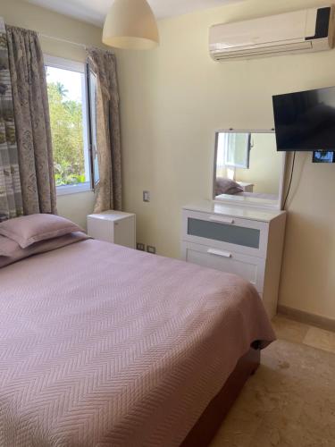 Schlafzimmer mit einem Bett und einem Spiegel in der Unterkunft Apartamento en la playa. in Punta Cana