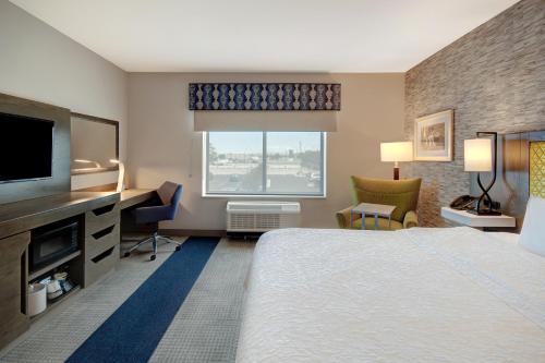 um quarto de hotel com uma cama grande e uma televisão em Hampton Inn Queen Creek, AZ em Queen Creek
