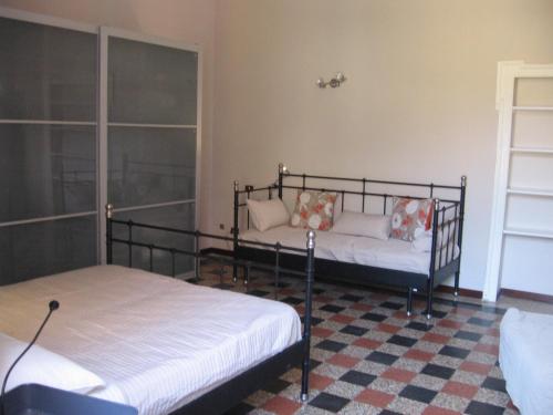 ミラノにあるAppartamento Loretoのベッドルーム1室(ベッド2台、ソファ付)
